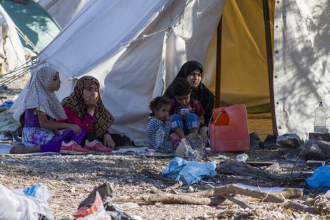 A family sits in wait at Kara Tepe transit camp in Lesbos Greece. Some refugees live here for up to a week waiting to hear their number called in order to be registered.